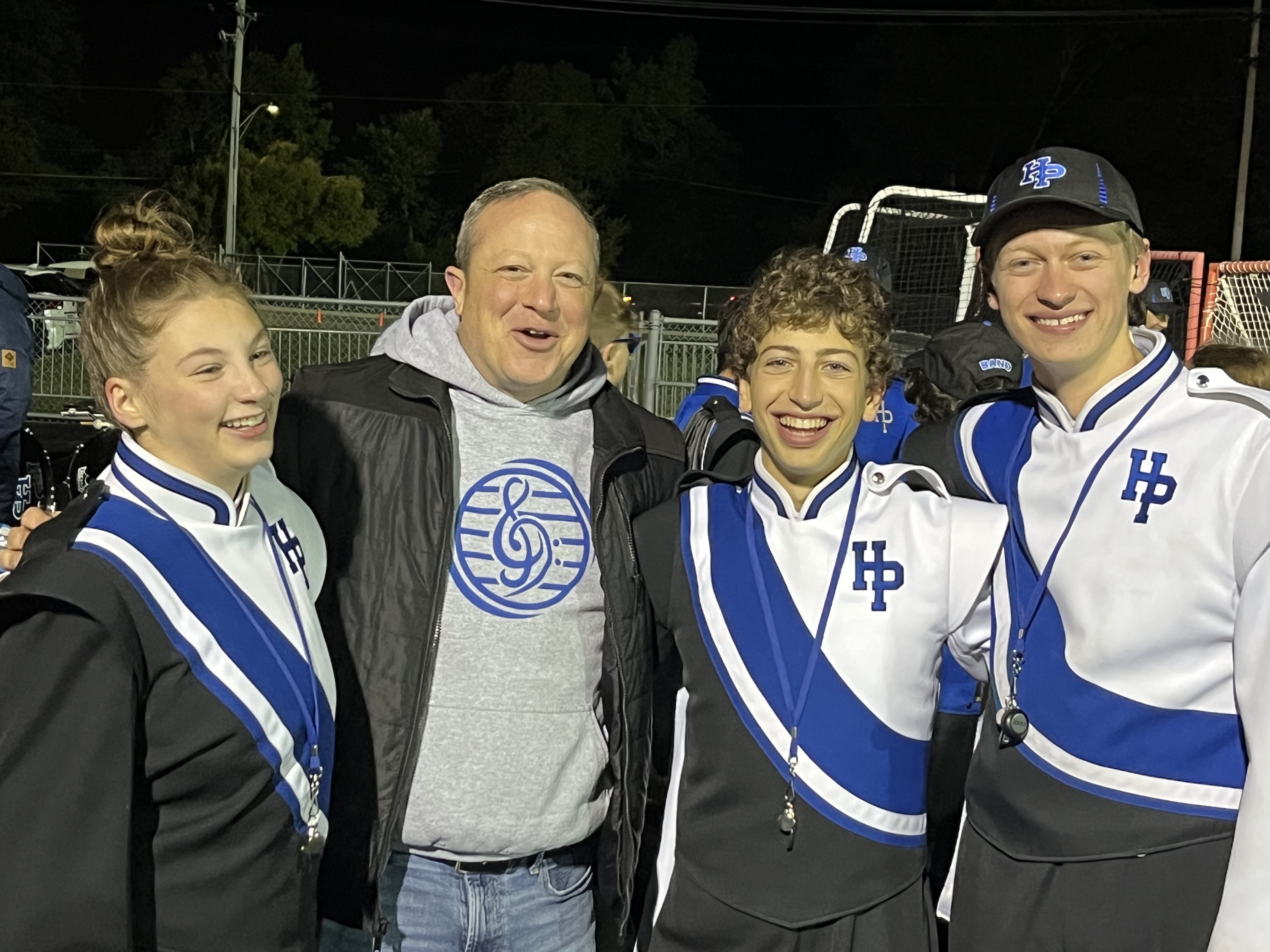 Posed picture of three drum majors and director